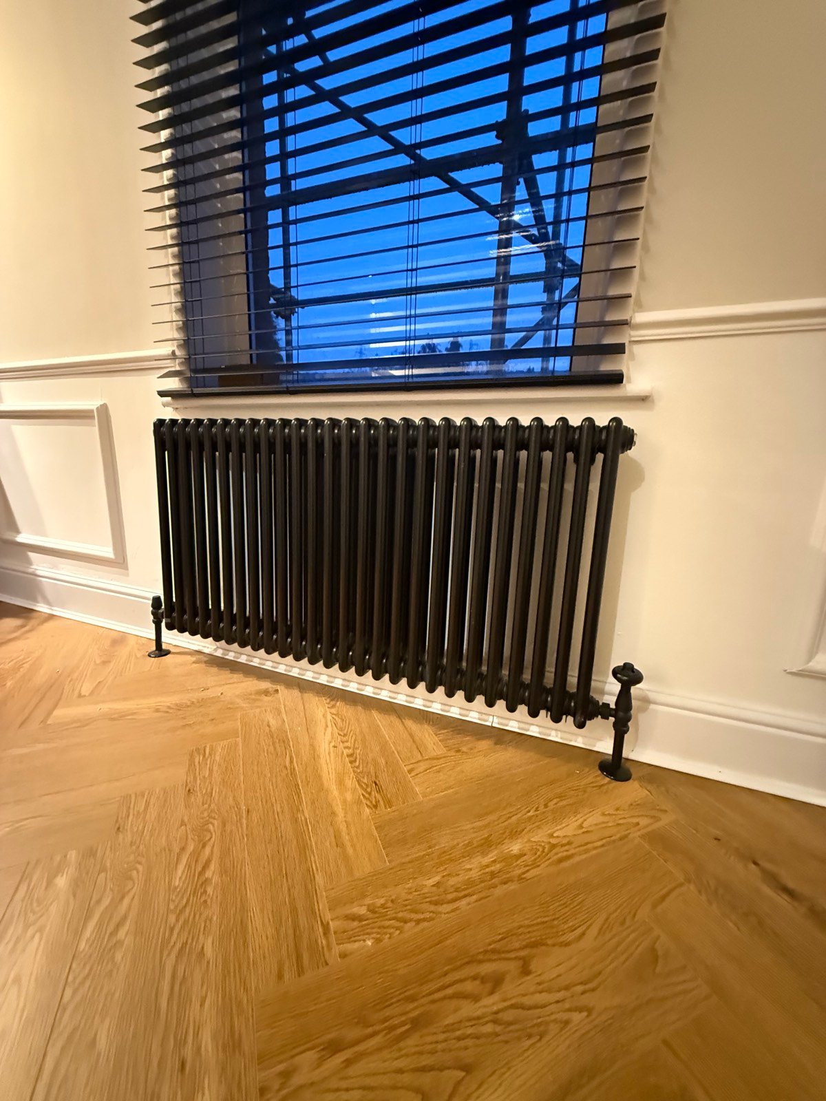 Traditional column radiator installed beneath a window